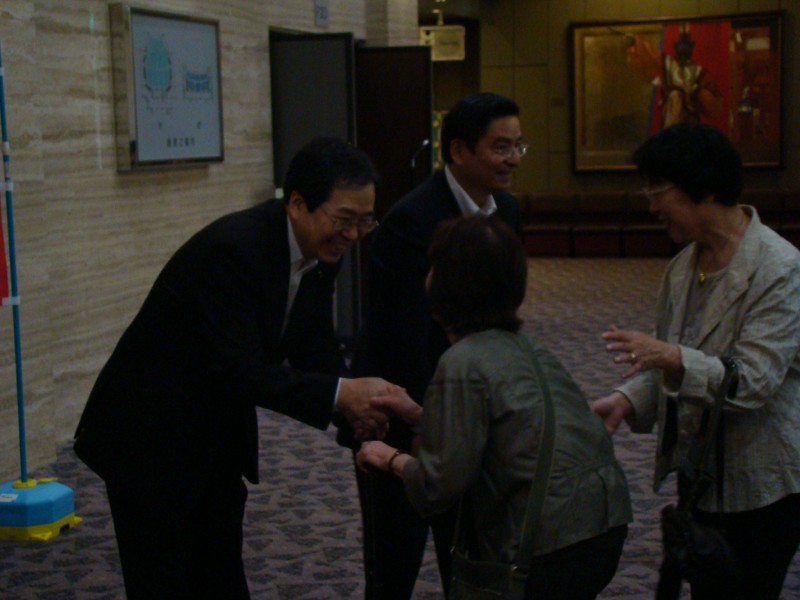参加者を出迎える 斉藤鉄夫（左）と山本ひろし参院議員