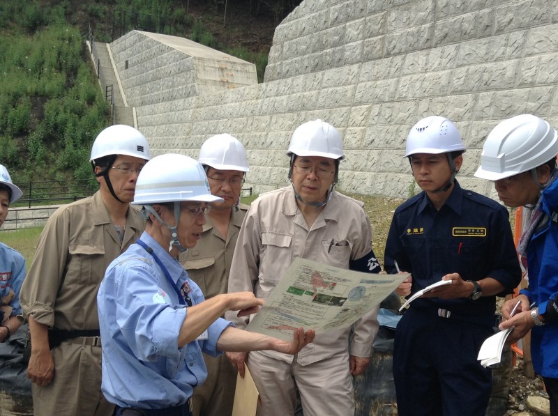 砂防堰堤で国交省担当者の説明を受ける 斉藤鉄夫（右から３人目）ら